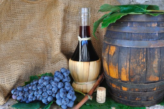 Fiasco di vino con grappolo d'uva