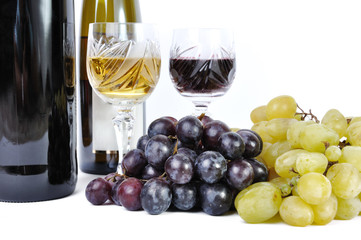 Two bottles of wine with two glasses of wine and grapes