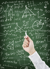 Hand writing maths formula on greenboard