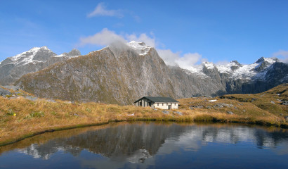 Mountains and hut lake reflection