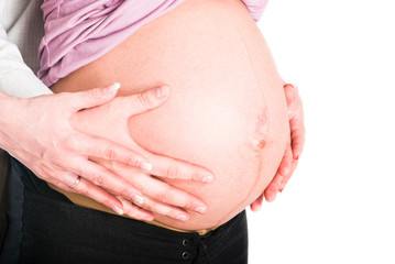 Male and female hands holding a pregnant woman belly