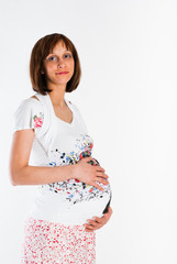Smiling pregnant woman holding belly on a white background
