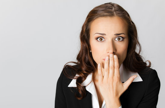 Business woman covering with hands her mouth