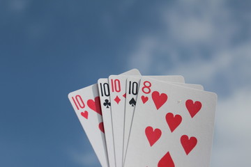 Poker hand - Four of a kind, with sky background