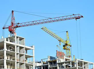 Crane and building construction site against blue sky