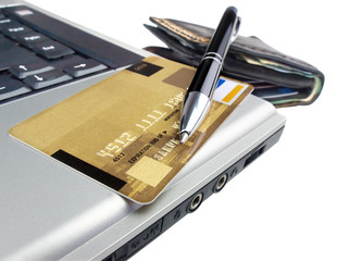 Credit card with pen on laptop ready for online purchase