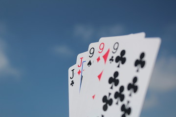 Poker hand - Full House, with sky background, the five cards