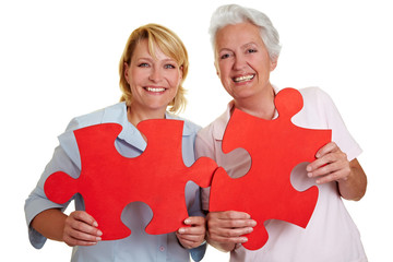 Frauen halten Puzzleteile
