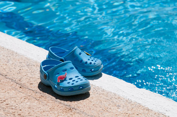 Chanclas azules al borde de piscina