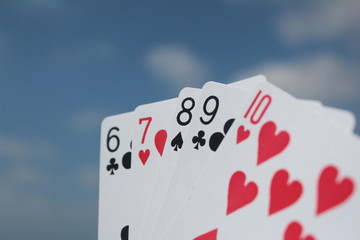 Poker playing cards with sky background - Straight Flush hand