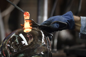 Glassmaker in factory creates bowl glass