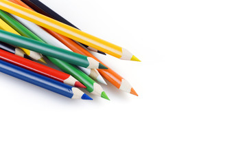 Multi colored pencils in a corner on a white background
