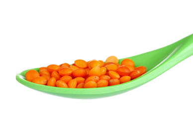 lentils in green plastic spoon isolated on white