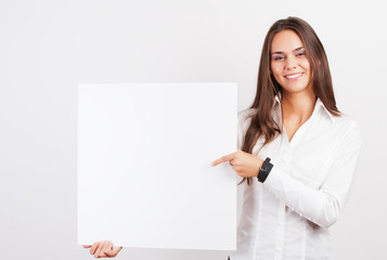 Happy smiling young business woman showing blank signboard