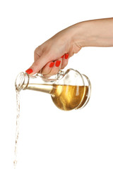 pouring olive oil from glass bottle on white background