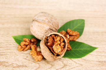 walnuts and leaves on wooden background