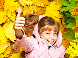Kid in autumn orange leaves.