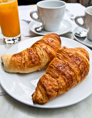 Breakfast with coffee and croissants on table