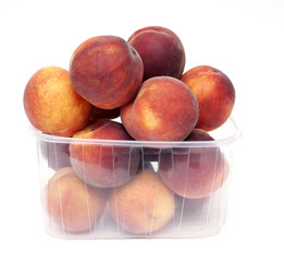 fresh and juicy peaches in a plastic box