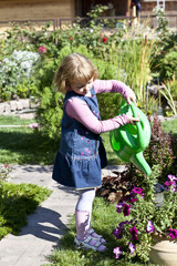 young girl in the garden with watering can