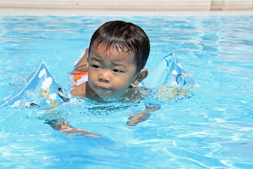 Fototapeta na wymiar プールで泳ぐ赤ちゃん
