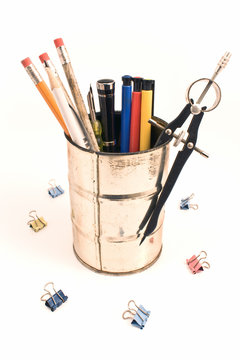 Pencils and pens in a tin holder