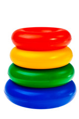 Colorful round plastic toys stacked over white background.