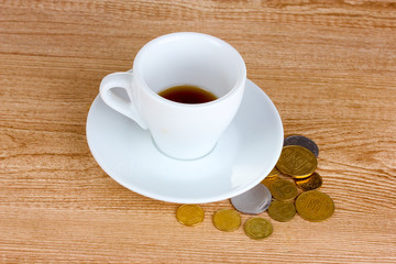 Obraz na płótnie Canvas Empty cup of coffee with coins tip on wooden background. Ukraini