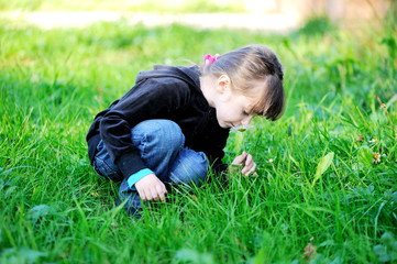 Fototapeta premium Brunette child girl smelling daisies in field