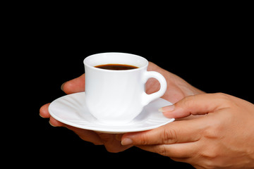 Hands with a cup of coffee on a black background