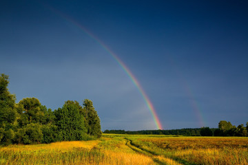 Landscape with country road and rainbow