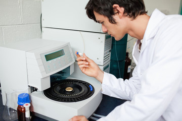 Obraz premium Young chemistry student using a centrifuge
