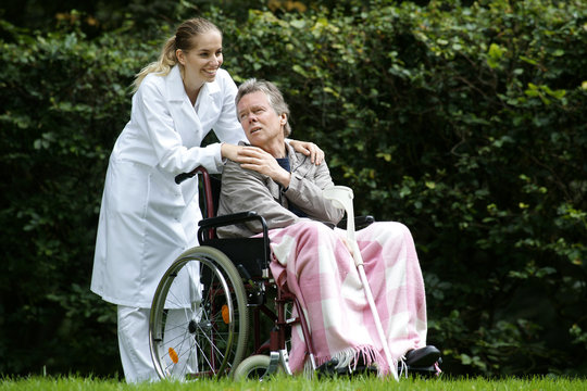Mann im Rollstuhl mit Pflegerin