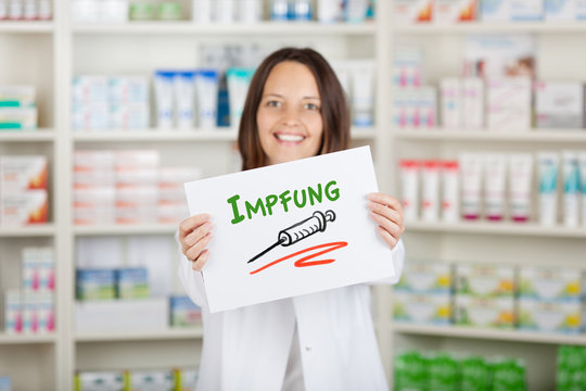 l&auml;chelnde apothekerin erinnert an impfung