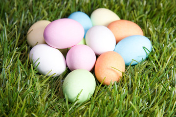 Fototapeta na wymiar several colored easter eggs in the green grass with white, blue, pink and orange