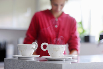 Two cups of hot tea with woman on a background