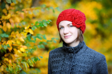 Young beautiful woman wearing red hat in autumn