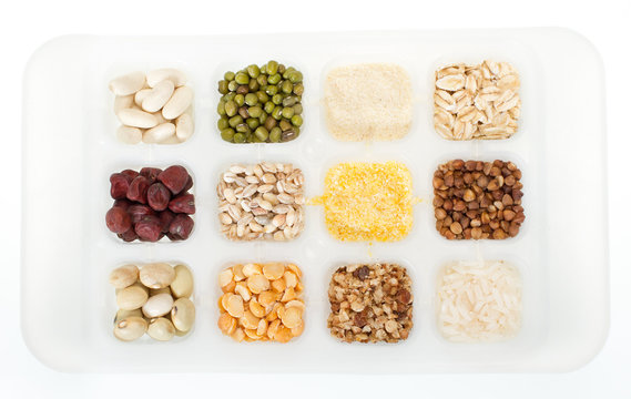 set of twelve sorts of cereals and grains on white tray. Closeup