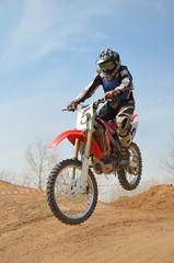Fototapeta na wymiar Racer motocykl Motocross wykonuje skok