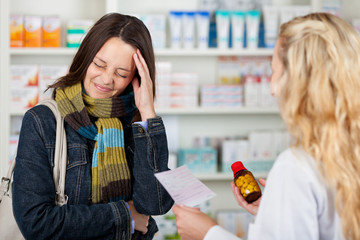 kundin mit kopfschmerzen in der apotheke