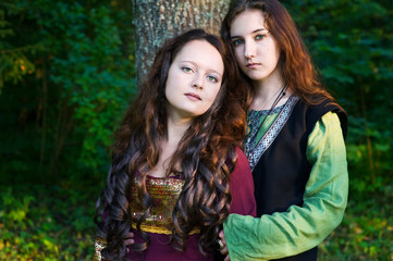 Fototapeta premium Two women in medieval dresses hugging