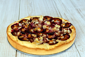 Plum pie and on a wooden background