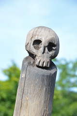 Wooden skull sculpture on the end of a pole