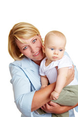 Glückliche Mutter trägt Baby