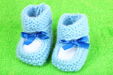 bright blue baby booties on green background