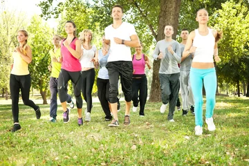Foto op Plexiglas grote groep joggen in het park © luckybusiness