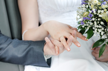 Obraz na płótnie Canvas Bride and groom holding each others hands