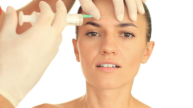Attractive woman gets botox injection in her face, isolated