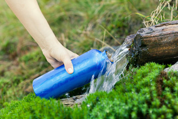 Water bottle and stream on hiking trip