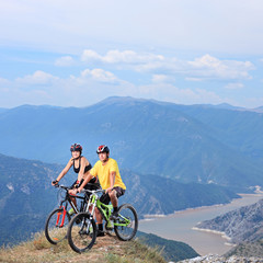 Fototapeta na wymiar Young female and male posing with a mountain bikes